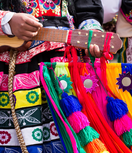 colorful peruvian dress with person playing a guitar
